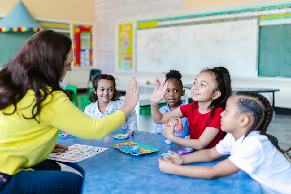 Teacher and diverse students high-five in a lively classroom setting.