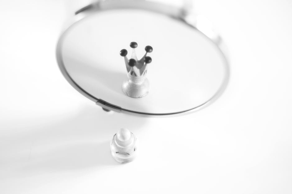 A creative black and white image showing a pawn's reflection as a crown, symbolizing self-perception.