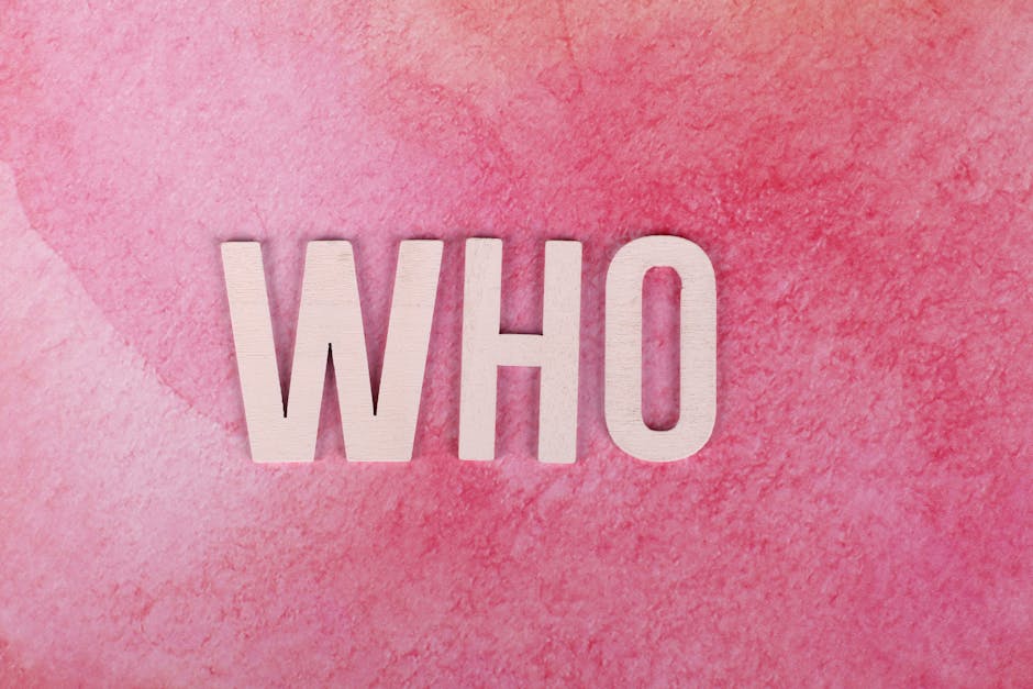 White wooden letters spelling 'WHO' on a textured pink background, offering ample copyspace.