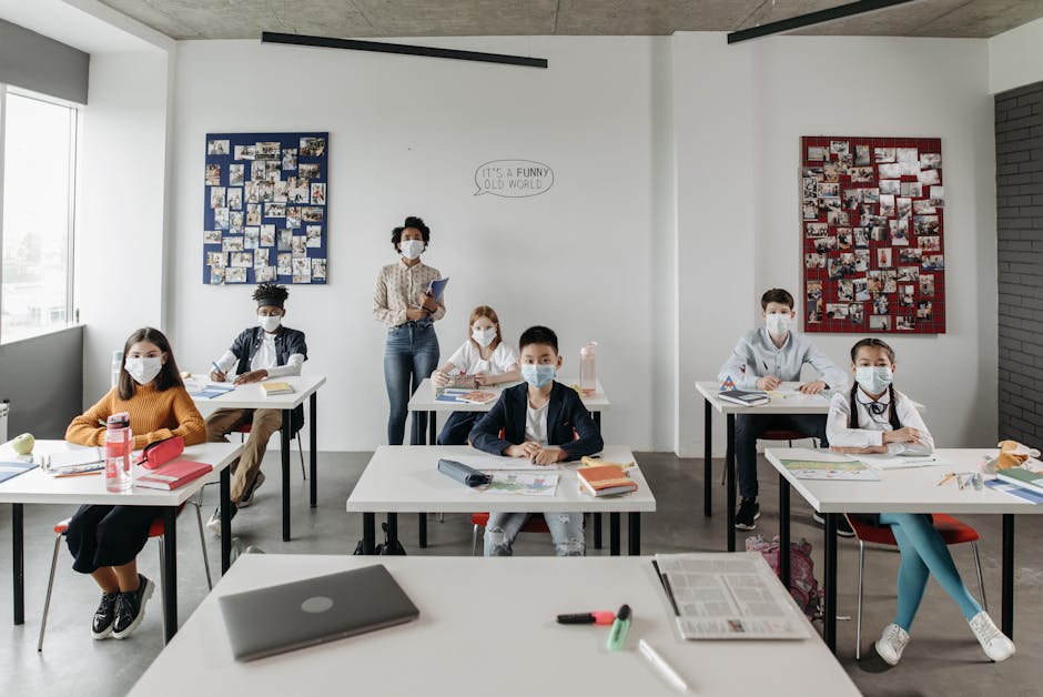 Diverse students and teacher wearing masks in a bright classroom setting.