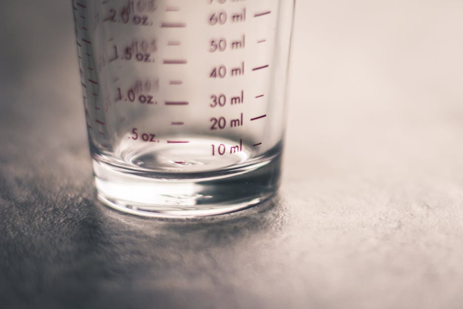 An artistic view of an empty measuring glass highlighting metric and ounce measurements.