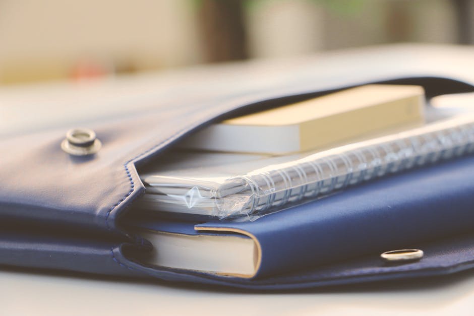 Close-up of a stylish blue portfolio containing various notebooks, creating an organized office look.