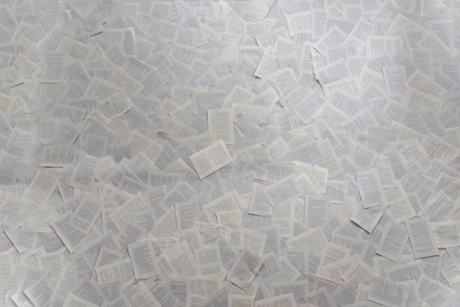 Abstract composition of numerous loose book pages overlapping indoors.