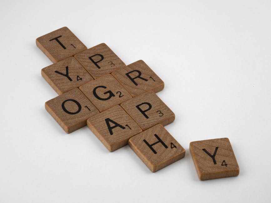 Close-up of Scrabble tiles spelling 'typography' on a white surface.