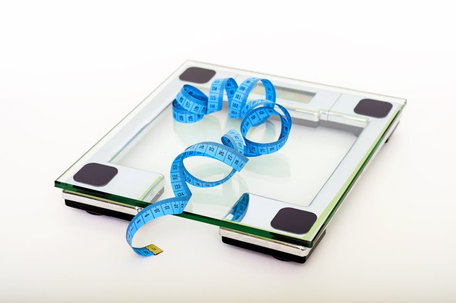 A digital glass weighing scale with a blue measuring tape, symbolizing weight management.