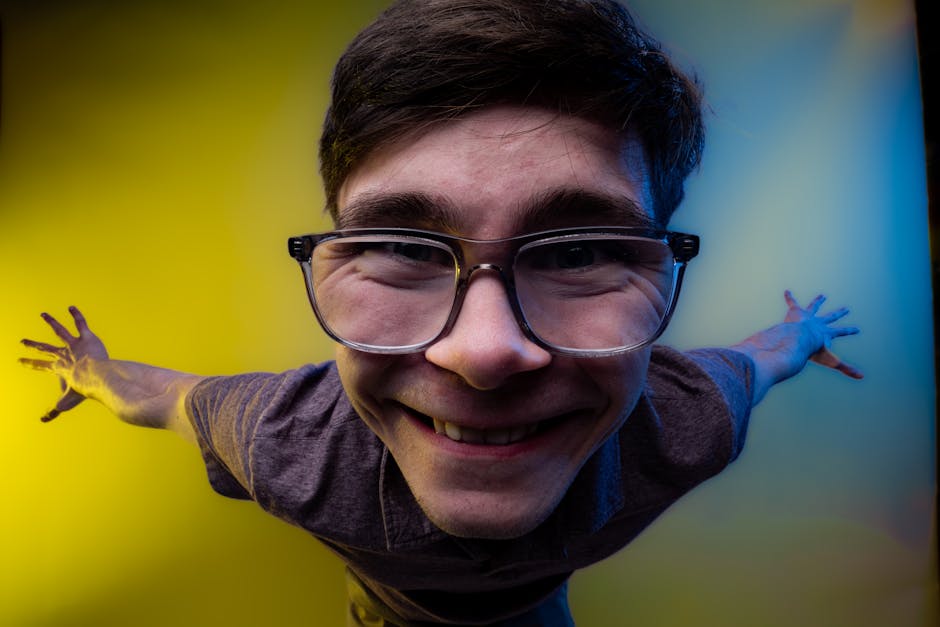 Playful portrait of a young man with a fisheye lens effect and colorful background.