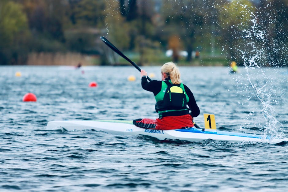 A back view of a woman kayaking energetically on a lake in Jönköping, Sweden.