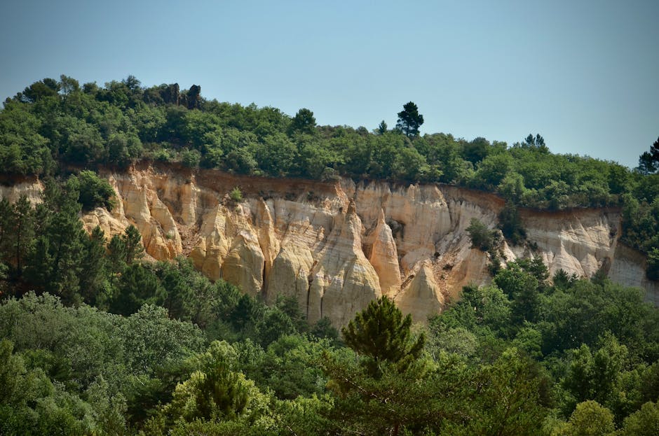 Beautiful ocher cliffs and lush greenery in Rustrel, Provence, captured on a sunny day.
