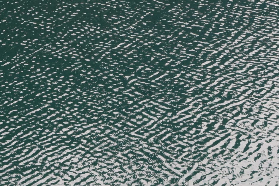 Close-up of rippling water surface with natural wave patterns and reflections.