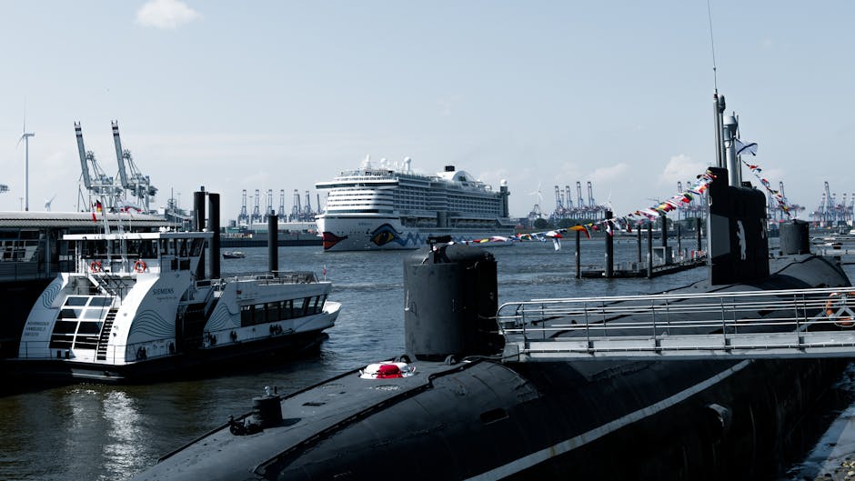 Cruise ship and submarine docked at vibrant Hamburg harbor on a clear day.