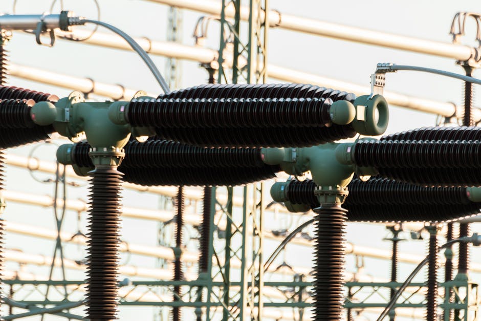 Close-up of outdoor electrical power equipment with insulators and conductors.