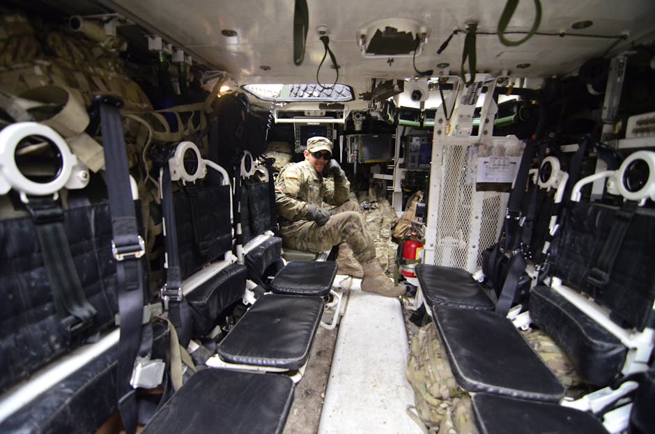 Soldier inside an armored vehicle, showcasing military equipment and seating.