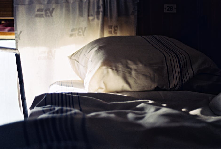 Soft morning light illuminates a cozy train cabin bed in Lviv, Ukraine.