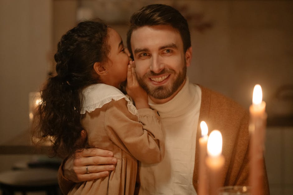 A father and daughter share a secret in warm candlelight, capturing a moment of love and bonding.