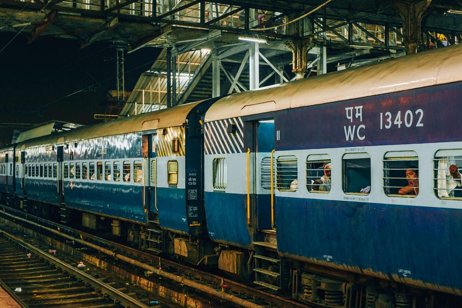 A train at a bustling railway station at night, capturing urban transportation.
