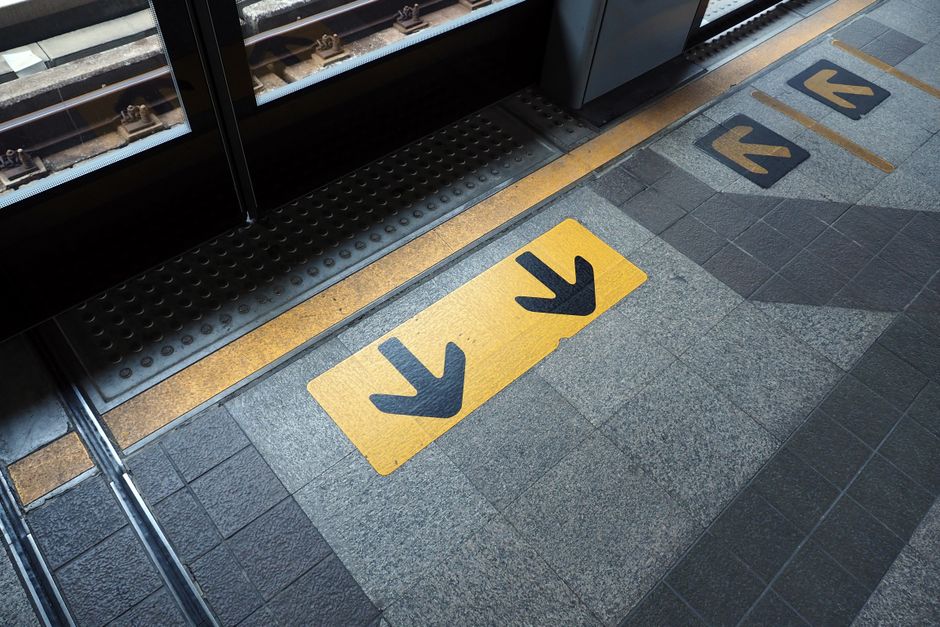 Urban metro platform showcasing guidance arrows and tracks.