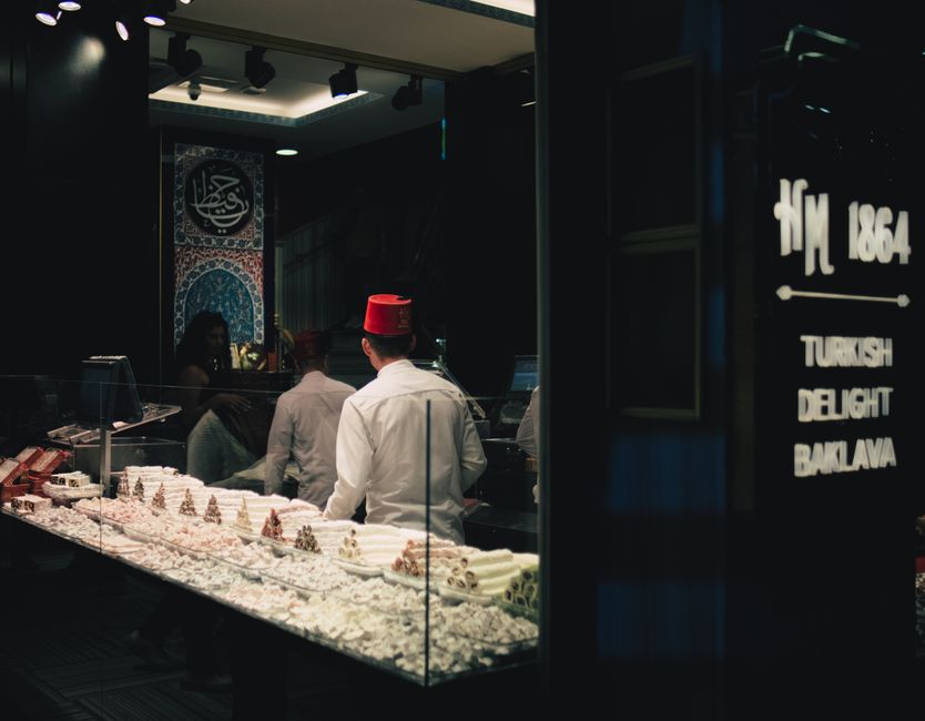 Interior of a Turkish delight shop in İstanbul with staff wearing red fez hats.