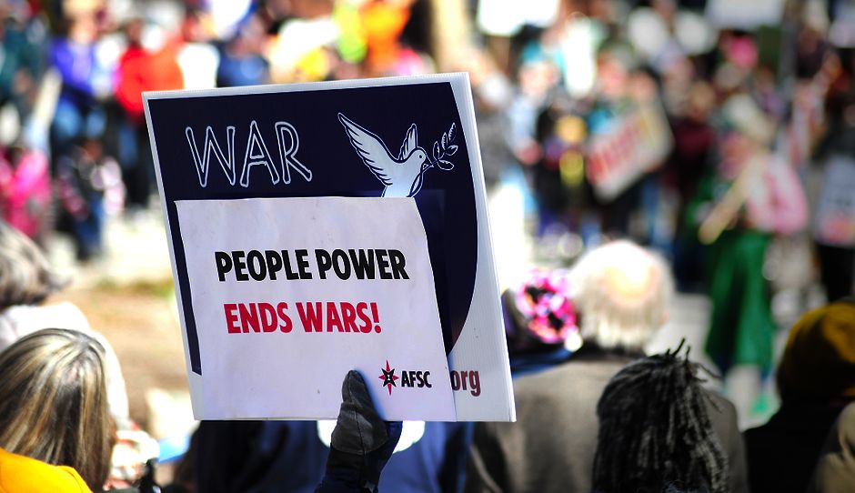 Protest sign reading 'People Power Ends Wars!' at a rally in Baltimore.