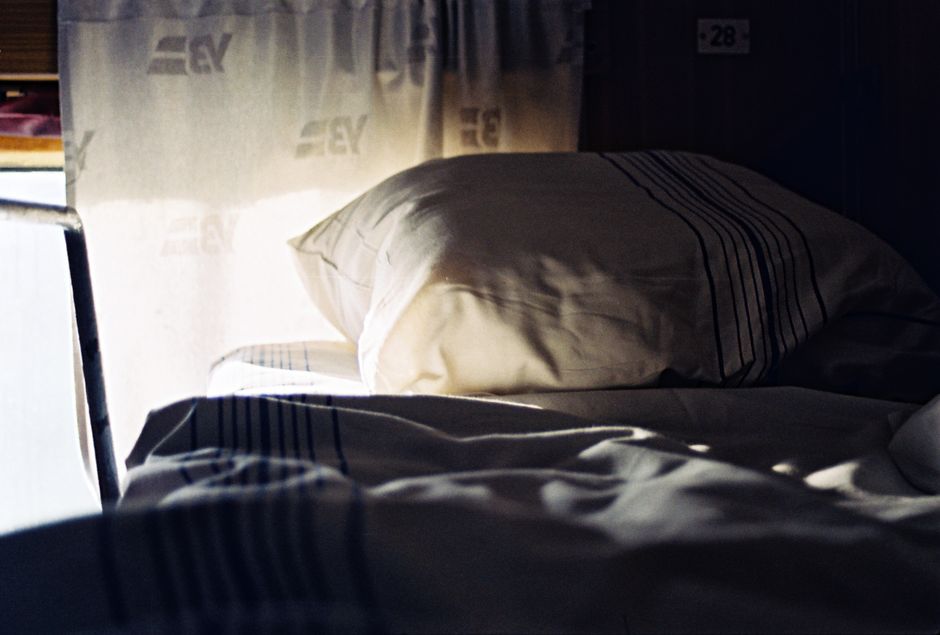 Soft morning light illuminates a cozy train cabin bed in Lviv, Ukraine.